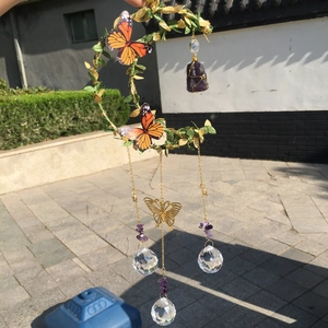 Detail of golden moon wind chime with orange butterflies and amethyst crystal clusters