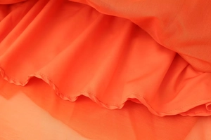 Macro shot of orange backless dress lining with smooth texture and fine stitching detail