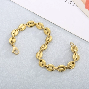 Detailed shot of a gold-tone stainless steel coffee bean chain bracelet with lobster clasp