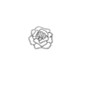 Broche rose ajourée argentée élégante sertie de cristaux sur fond blanc neutre