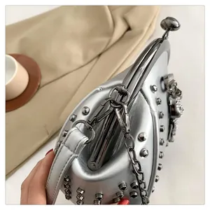 Macro shot of silver studded shell bag with metallic kiss-lock and chain strap detail