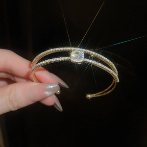 Macro shot of double-row gold zircon bow bracelet with sparkling center square diamond
