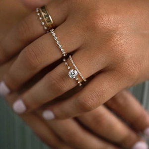 Detail of luxurious K-gold rings with brilliant round diamond and pavé settings on hand