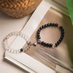Magnetic couples bracelets with black and white matte beads and heart shaped metal clasp