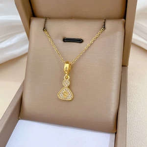 Macro shot of gold stainless steel necklace featuring a crystal-encrusted S letter pendant