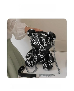Close-up of black bear-shaped crossbody bag featuring white graffiti and silver chain