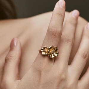 Detailed shot of gold-plated double flower ring showcasing 3D petals and metallic texture
