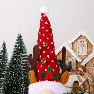Close-up of red knit gnome with reindeer antlers and metal bells on a holiday background