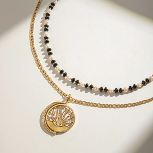 Double-layered stainless steel necklace with faux pearls and sunburst evil eye pendant