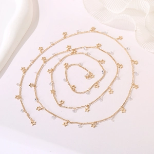 Detail of a gold body chain featuring hollow star pendants and clear crystal beads