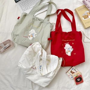 Trio of drawstring canvas bags with dog embroidery in red, green and beige
