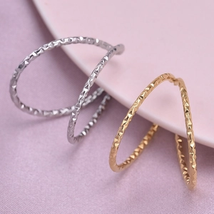 Minimalist V-shaped open rings in gold and silver with textured geometric pattern