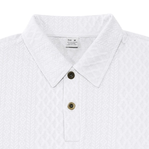 Detail shot of men's white knit polo shirt featuring waffle texture and premium buttons