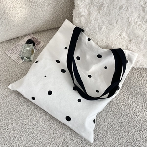 Detailed view of polka dot canvas tote bag on soft fleece with vintage lifestyle props