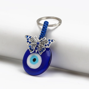 Close-up of blue Evil Eye keychain with glass bead and rhinestone butterfly pendant