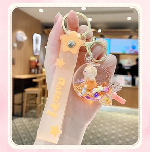 Macro shot of a bunny charm liquid glitter keychain with starry sand and orange strap