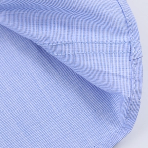 Close-up of blue and white striped shirt fabric with detailed double-needle stitching