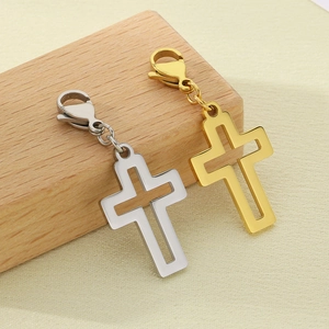 Detailed view of hollow cross pendants in gold and silver steel on wooden blocks