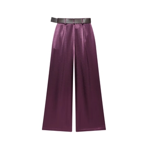 Detail van een dieppaarse satijnen broek met wijde pijpen en een bijpassende riem