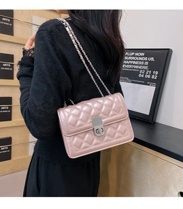 Pink quilted leather chain bag detail with silver metal lock and adjustable shoulder strap