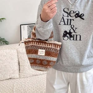 Détail du sac à main en peluche avec motifs géométriques marrons et étiquette de marque