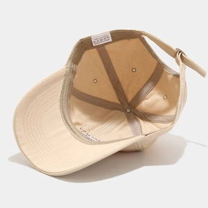 Inside view of beige cotton baseball cap with sweatband and adjustable metal buckle