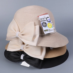 Détail de chapeaux en paille avec ruban de perles et étiquettes de protection solaire UPF 50+