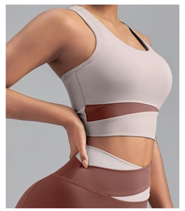 Gros plan d'un soutien-gorge de sport bicolore mauve et marron avec legging de yoga