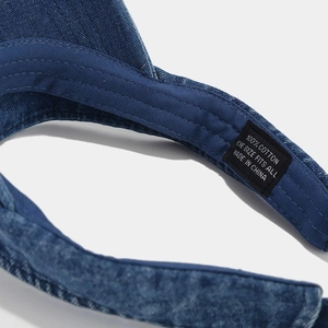 Macro shot of stitching details and 100% cotton label on the denim sun visor cap