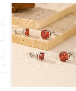 Détail de pierres rouges sur boucles d'oreilles en argent 925 avec gravure précise