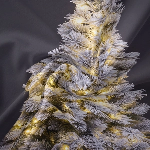 Dettaglio del tessuto morbido con motivo ad albero di Natale e calde luci soffuse