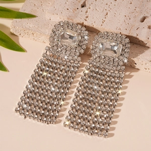 Detail view of silver tassel earrings with rectangular crystals and rhinestones on stone
