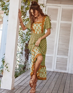 Bohemian floral maxi dress with square neck and high slit on a wooden patio
