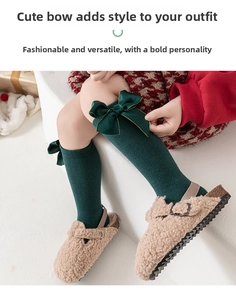 Détail de chaussettes hautes en coton vert foncé avec nœud satin et sandales sherpa