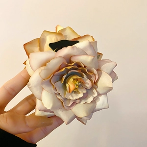 Vue détaillée de la pince à cheveux avec fleur en tissu dégradé beige et rose