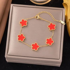Detail of five-motif red clover bracelet in gold finish with S.STEEL engraved tag