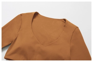 Détail du haut de yoga caramel à col en V montrant un tissu lisse et des coutures soignées