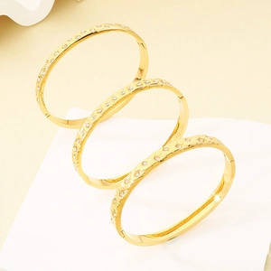 Detailed view of three 18K gold plated bangles with different textured patterns and zircon