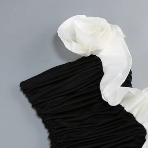 Detail of elegant 3D white flower on black ruched satin fabric for an evening gown