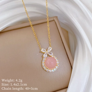Macro view of pink crystal necklace with bow pendant and detailed size specifications