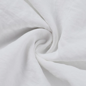 Macro de tissu blanc tissé montrant la texture détaillée et les plis souples de la robe