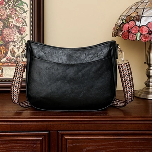 Dettaglio borsa vintage nera con tracolla boho intrecciata e chiusure in oro lucido