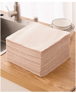 Stack of absorbent beige microfiber dishcloths on a kitchen wooden countertop