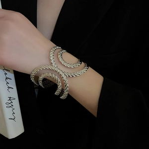 Macro detail of silver twisted texture cuff bracelet showing irregular multi-layered design