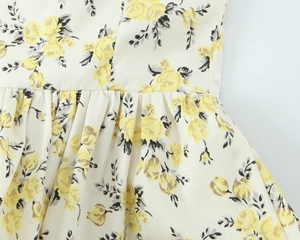 Detail of floral poplin midi dress showing waist pleats and yellow rose print