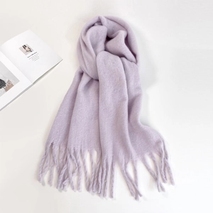 Detailed close-up of soft lavender knitted scarf with decorative long fringe tassels
