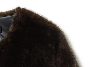 Detail of dark brown faux fur bomber jacket with smooth black leather lining