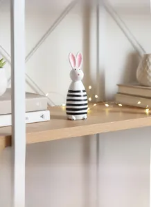 Dettaglio decorazione a coniglio in legno a righe bianche e nere in ambiente domestico