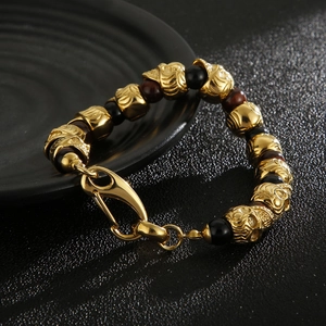 Men's skull bracelet featuring tiger eye and lava stones on a textured black surface
