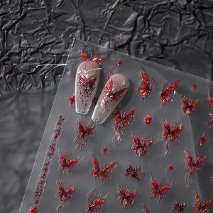 Detail of red butterfly and star nail stickers with embossed glitter effect on black base